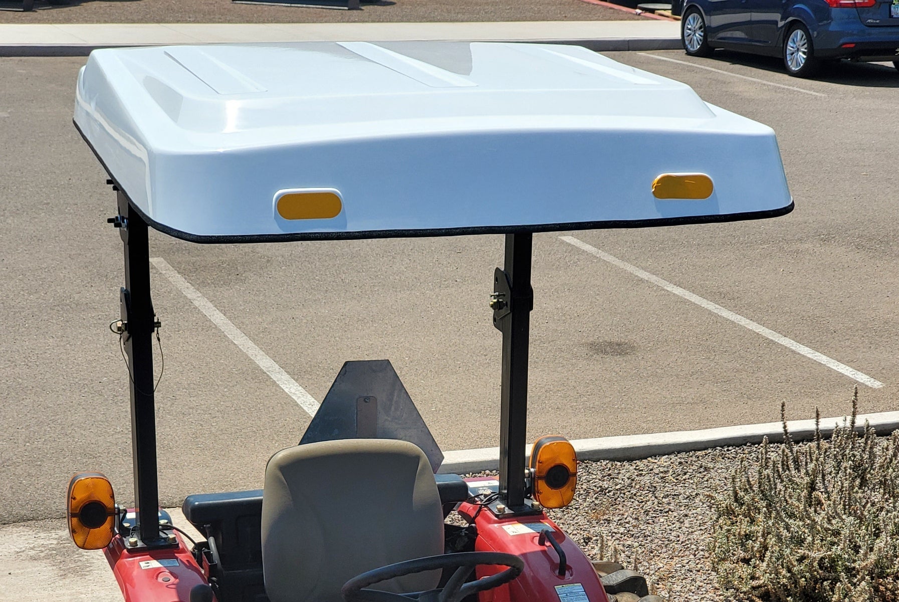 Case IH tractor with a white Tractor Sunshade R-Series canopy mounted above the open operator station.