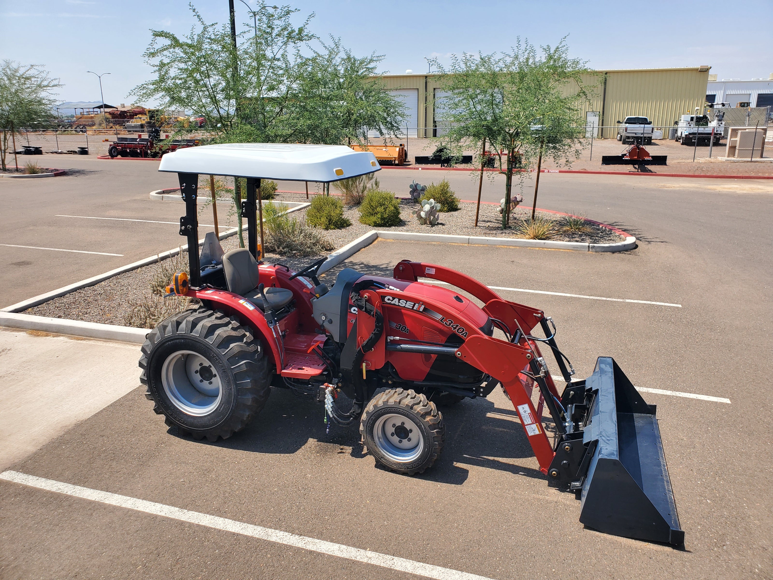 Red Case IH tractor equipped with a Tractor Sunshade fiberglass canopy.