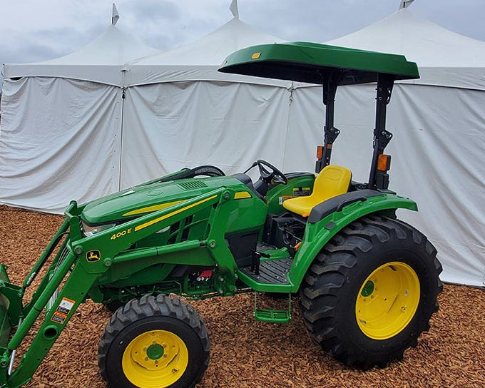 John Deere compact utility tractor equipped with a green Tractor Sunshade R1 R-Series fiberglass canopy.