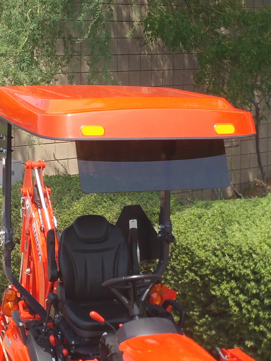 Front view of a Kubota tractor equipped with an orange Tractor Sunshade R-Series canopy and a dark tinted visor accessory beneath the canopy edge.