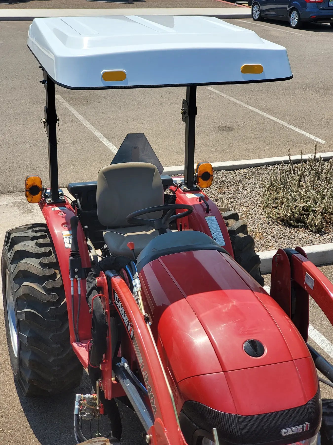 Red Case IH tractor equipped with a white Tractor Sunshade R-Series fiberglass canopy and black dual-post supports.